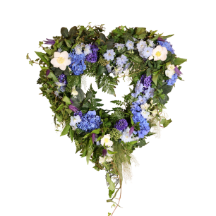 Hjärtformad blomsterkrans med blå, vita och lila blommor samt gröna blad.