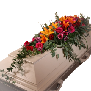 Vit kista dekorerad med färgglada blommor, inklusive orange liljor och rosa rosor.