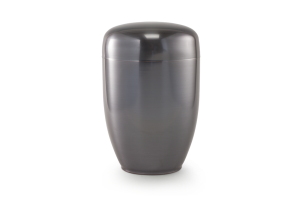 En slät, mörkgrå urna med kupolformat lock, stående på en ljus yta.